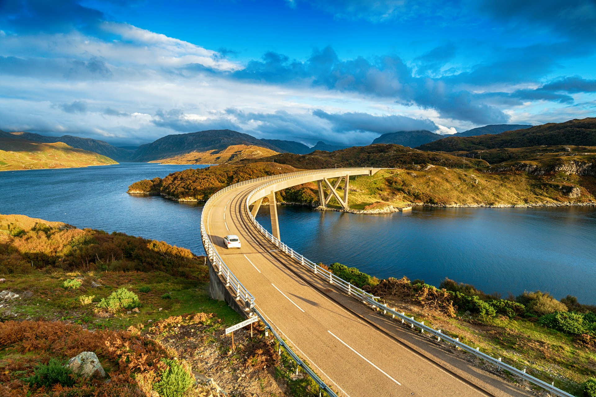 The Kylesku Bridge spanning Loch a' Chàirn Bhàin in the Scottish Highlands, which is a landmark on the North Coast 500 tourist driving route