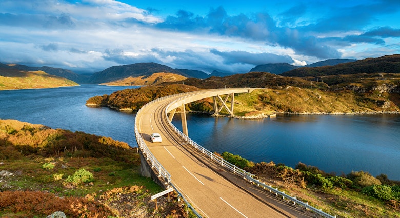 The Kylesku Bridge spanning Loch a' Chàirn Bhàin in the Scottish Highlands, which is a landmark on the North Coast 500 tourist driving route.