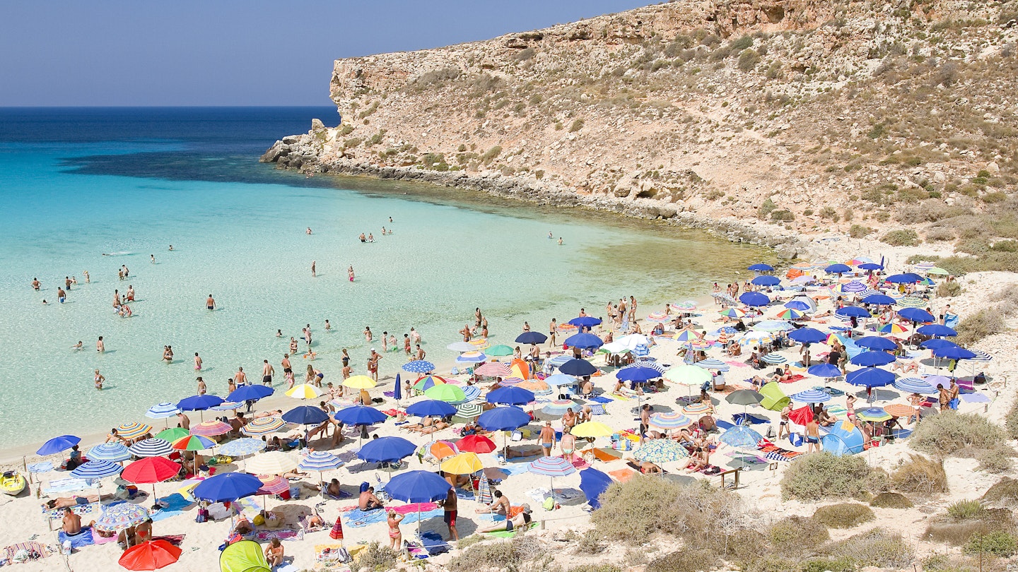Tourists on the beach Spiaggia dei Conigli on Lampedusa, Sicily, Italy.