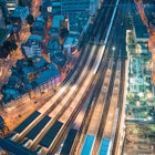 London. Train station and Tower Bridge night lights, aerial view.