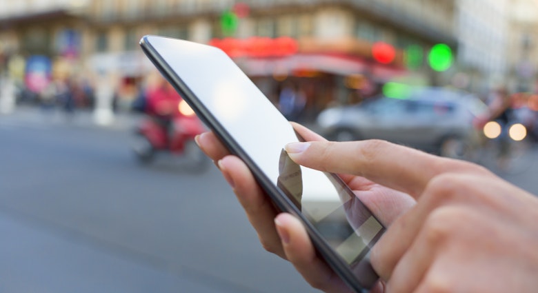 Woman uses her smart phone on the street in Paris