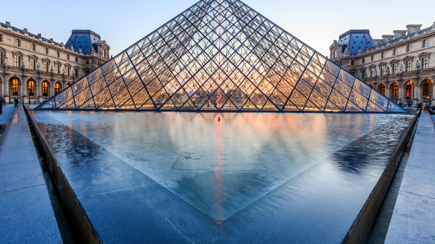 PARIS, FRANCE - JULY 19: The Louvre Pyramid at dusk during the Michelangelo Pistoletto Exhibition on July 19, 2014 in Paris. The Pyramid is the main entrance to the Louvre Museum.