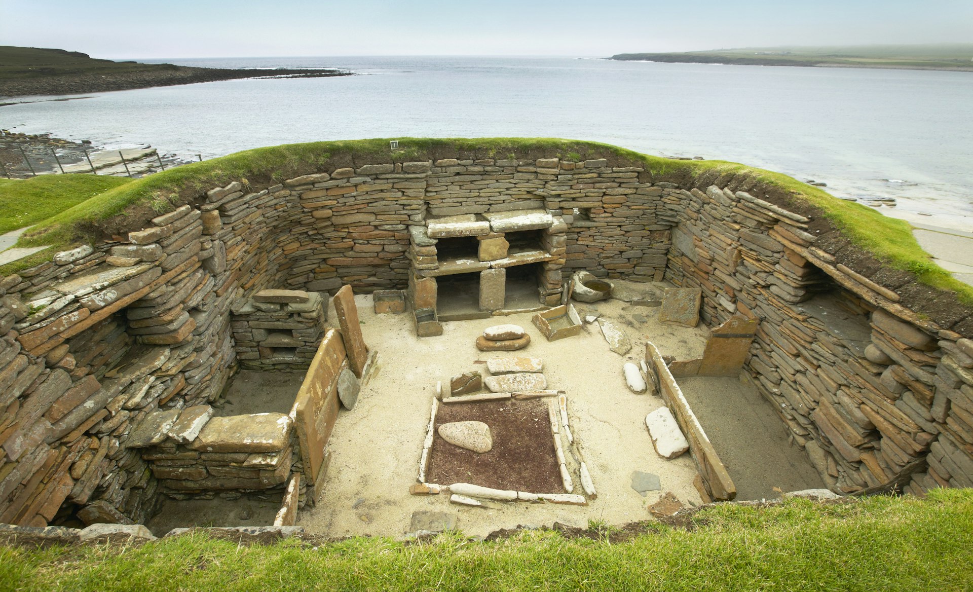 A roofless room dug into the ground, with stones stacked around the edges to support the walls