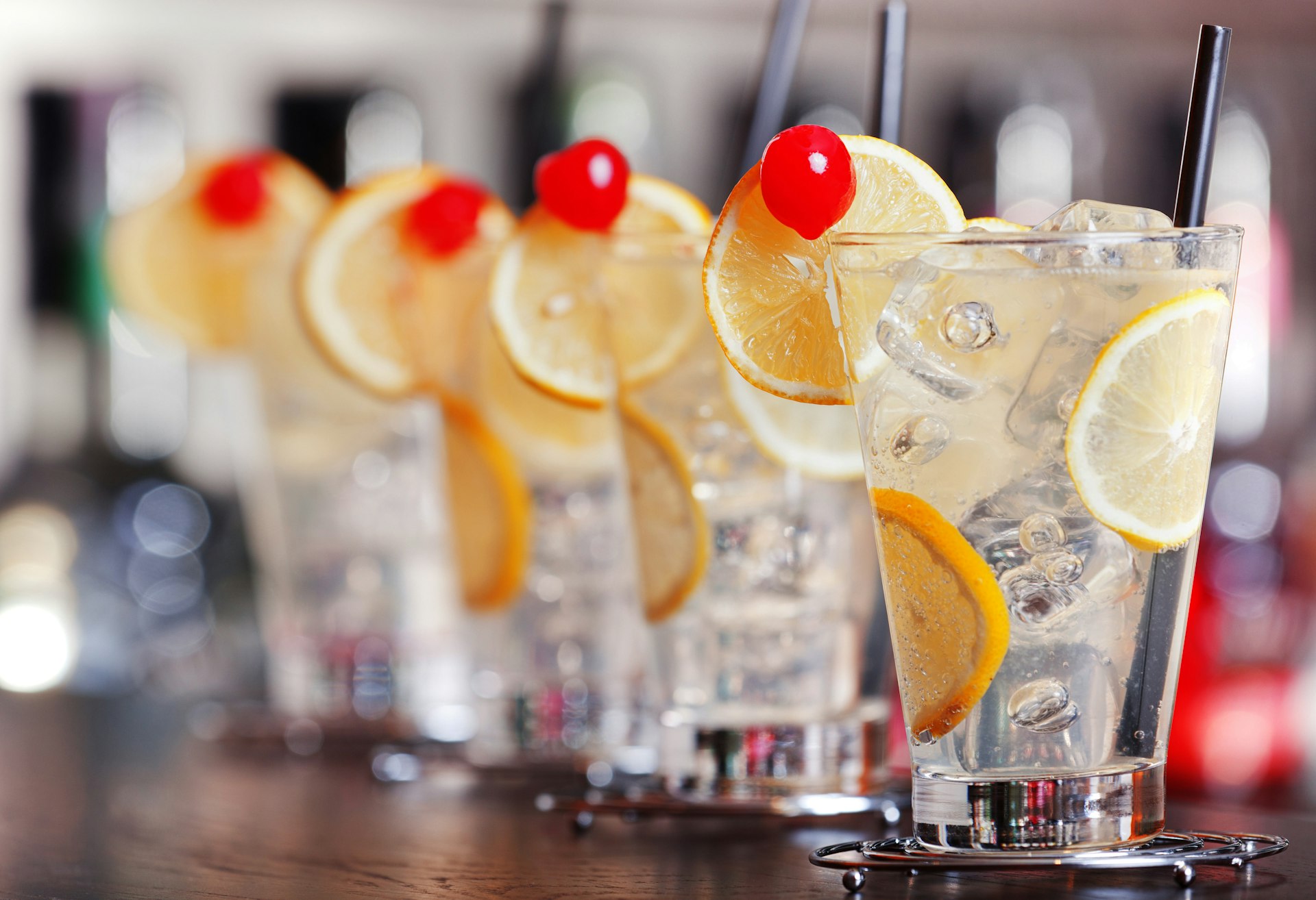 Four Tom Collins cocktails on a bar