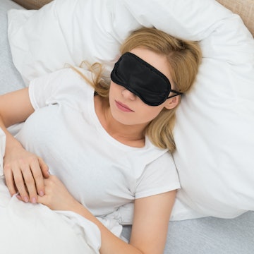 Young Woman Sleeping With Sleep Mask In Bedroom