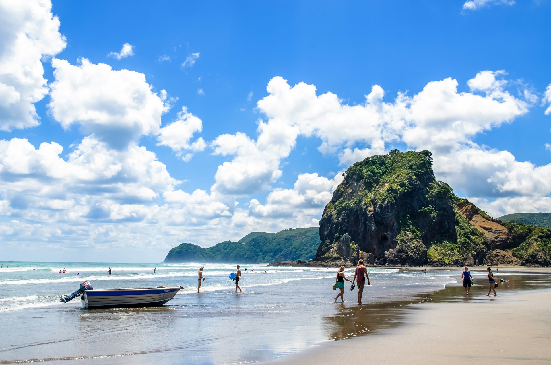 People can seen exploring and relaxing around Piha beach, on Auckland's west coast 