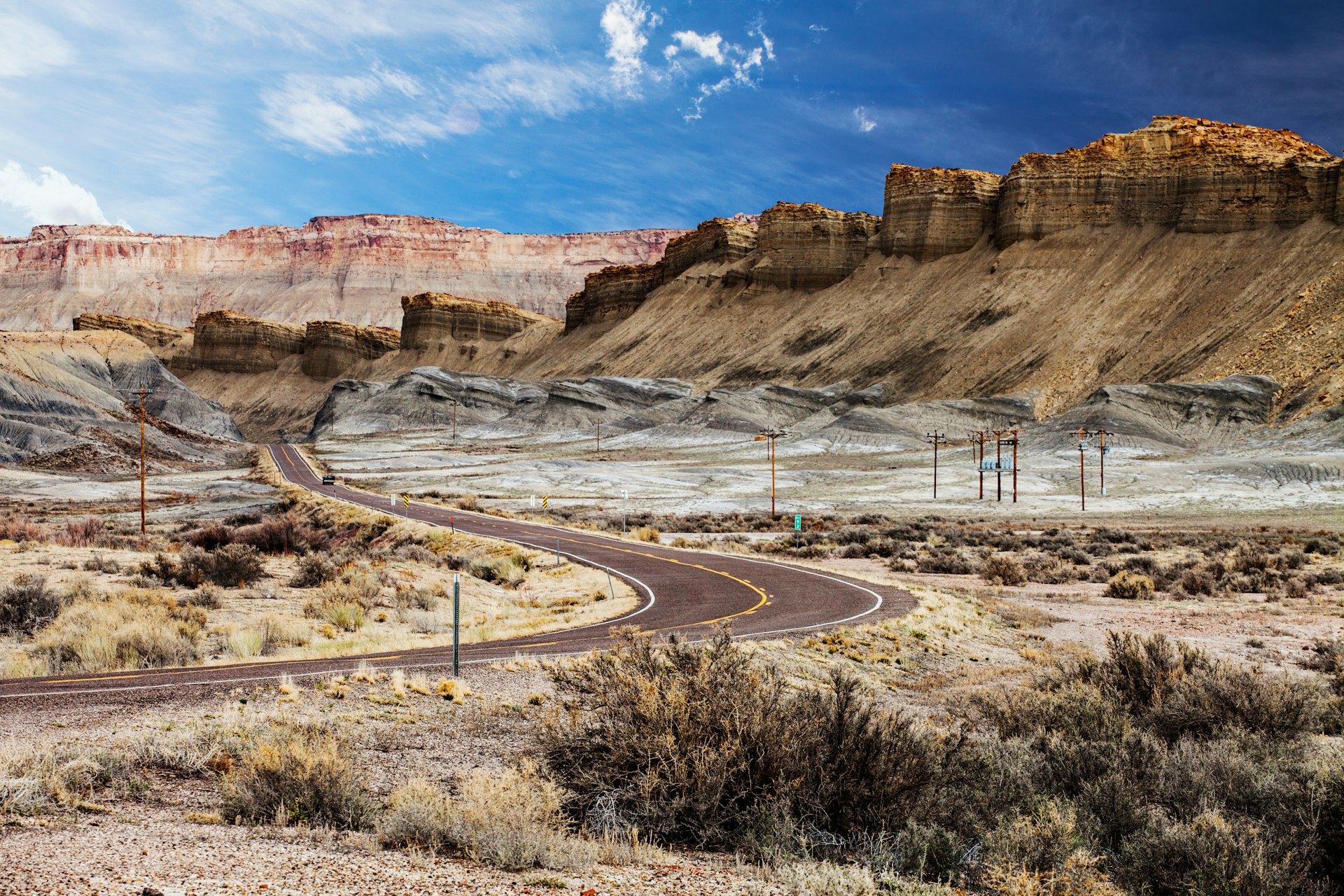 A road winds through incredible natural stone formations in the shape of stepping stones that tower above the road