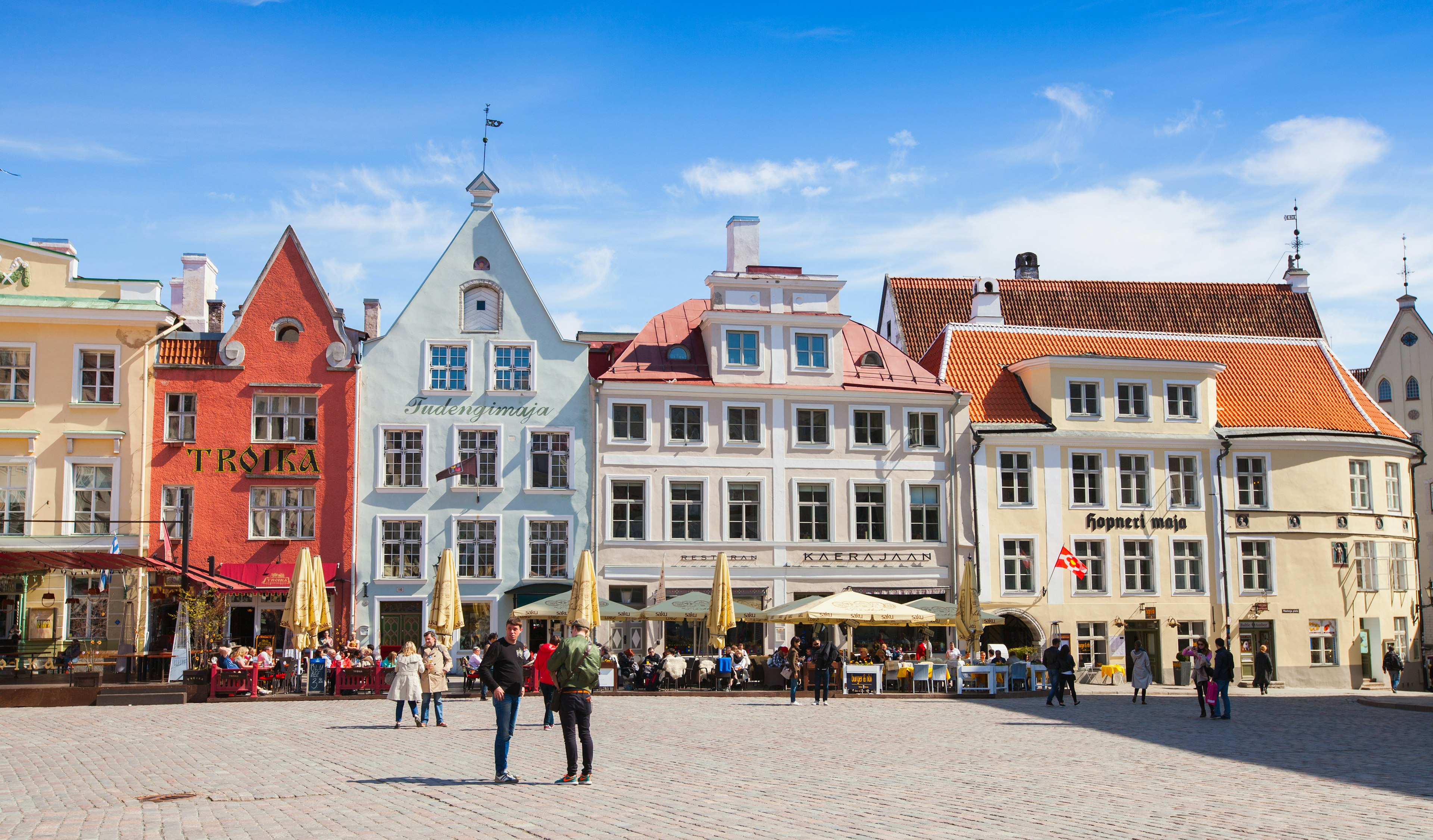 Tourists walking on Town Hall square in central old Tallinn