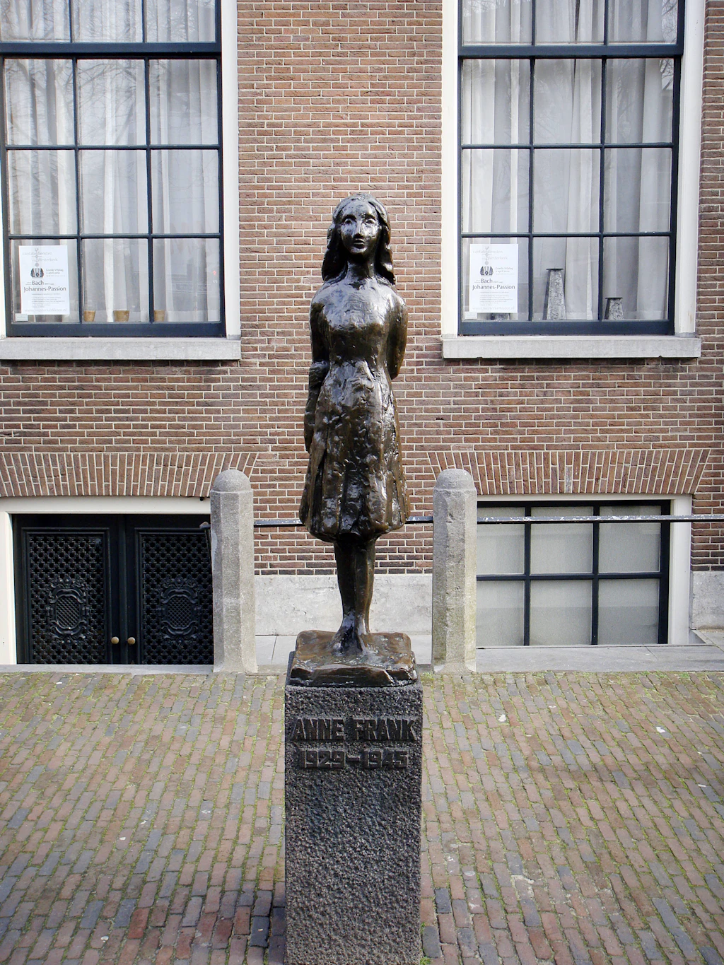 Anne Frank memorial statue, Amsterdam A bronze statue of a teenage girl on a plinth standing proud outside a former industrial building