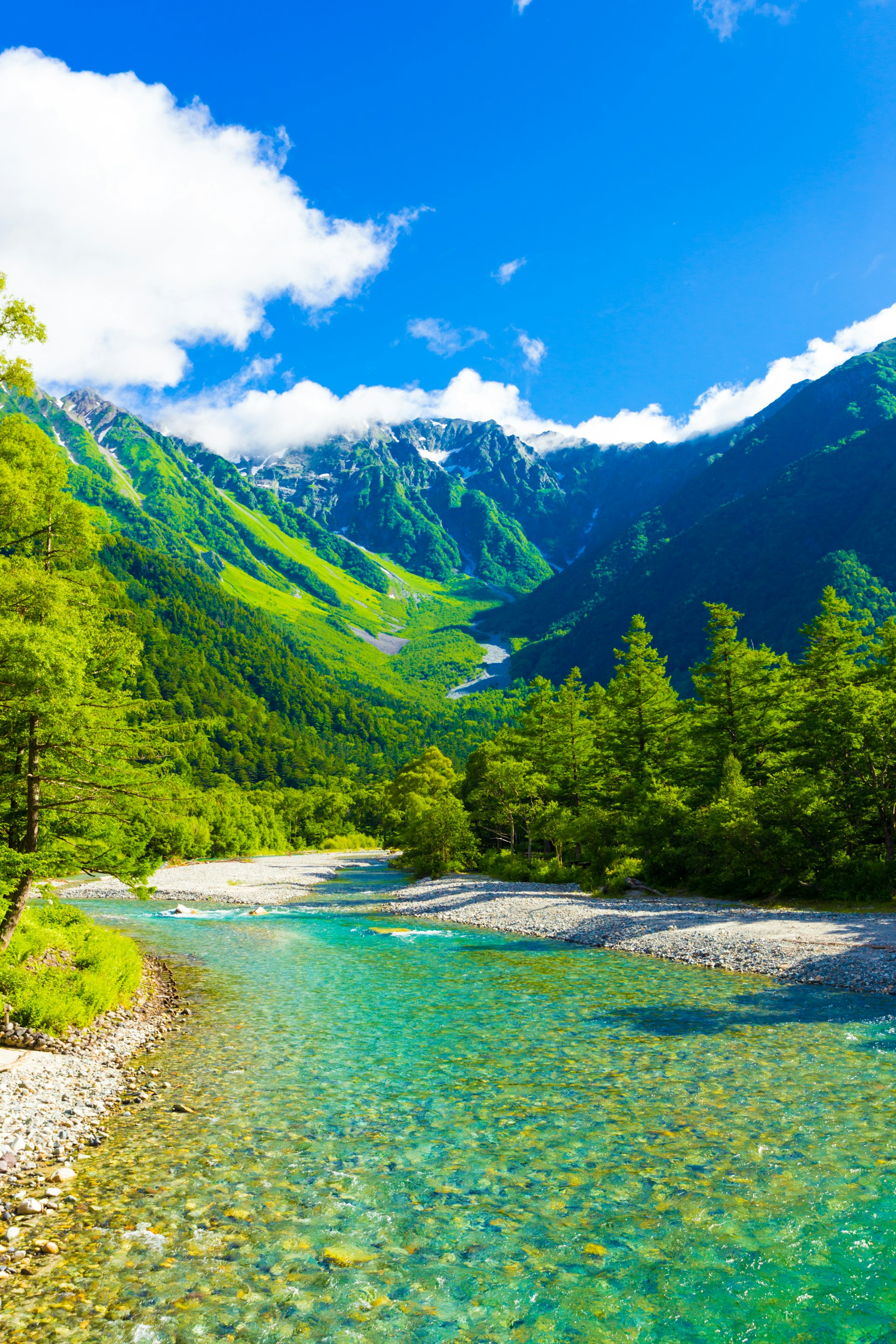 A pristine clear green-blue river flows in a mountainous region