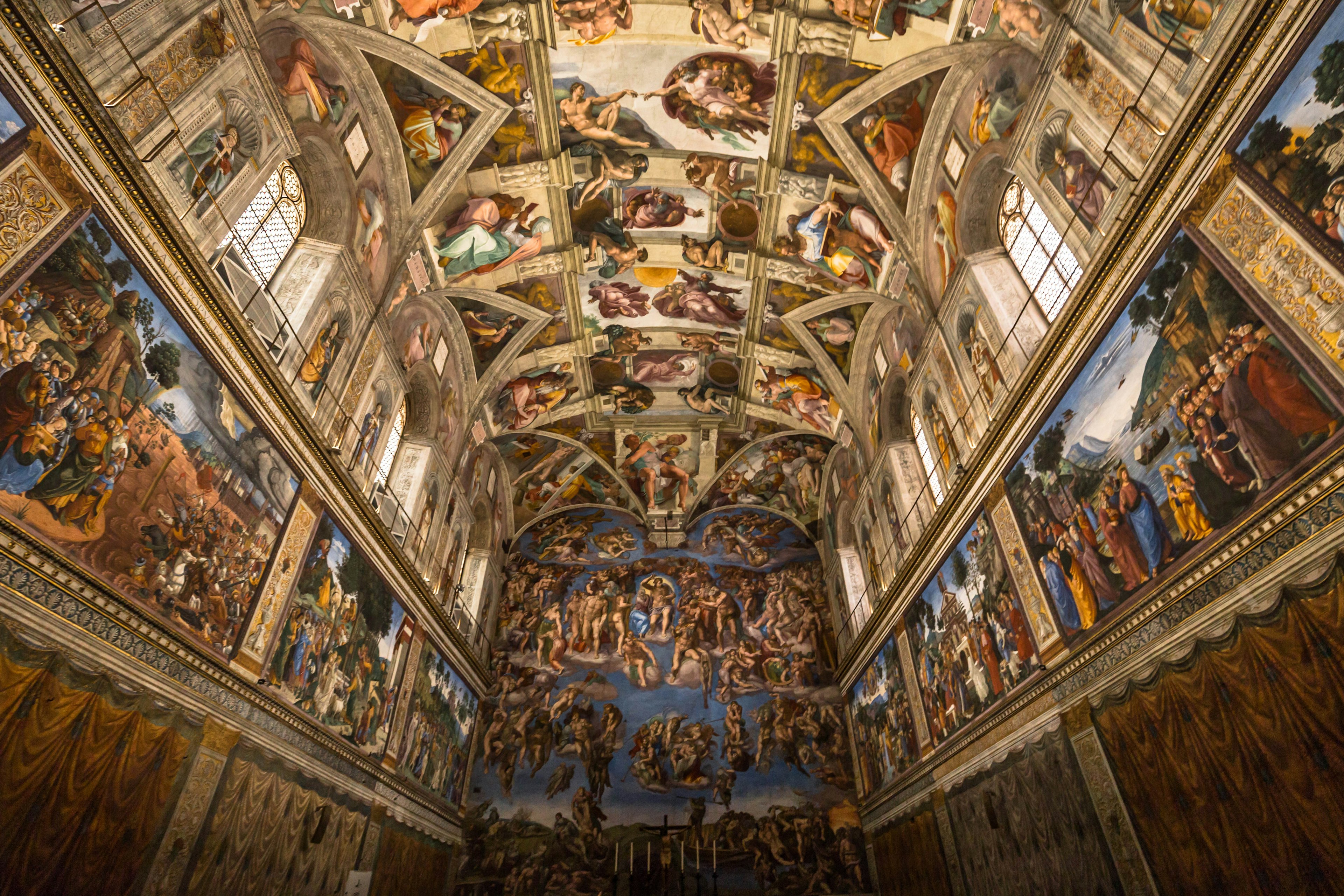 Thousands of fresco paintings cover the arched ceiling of a chapel, Sistine Chapel, Vatican Museum