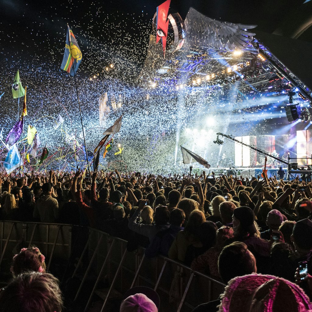 An explosion of confetti, tape and light from a pyramid shaped stage at Glastonbury Festival.