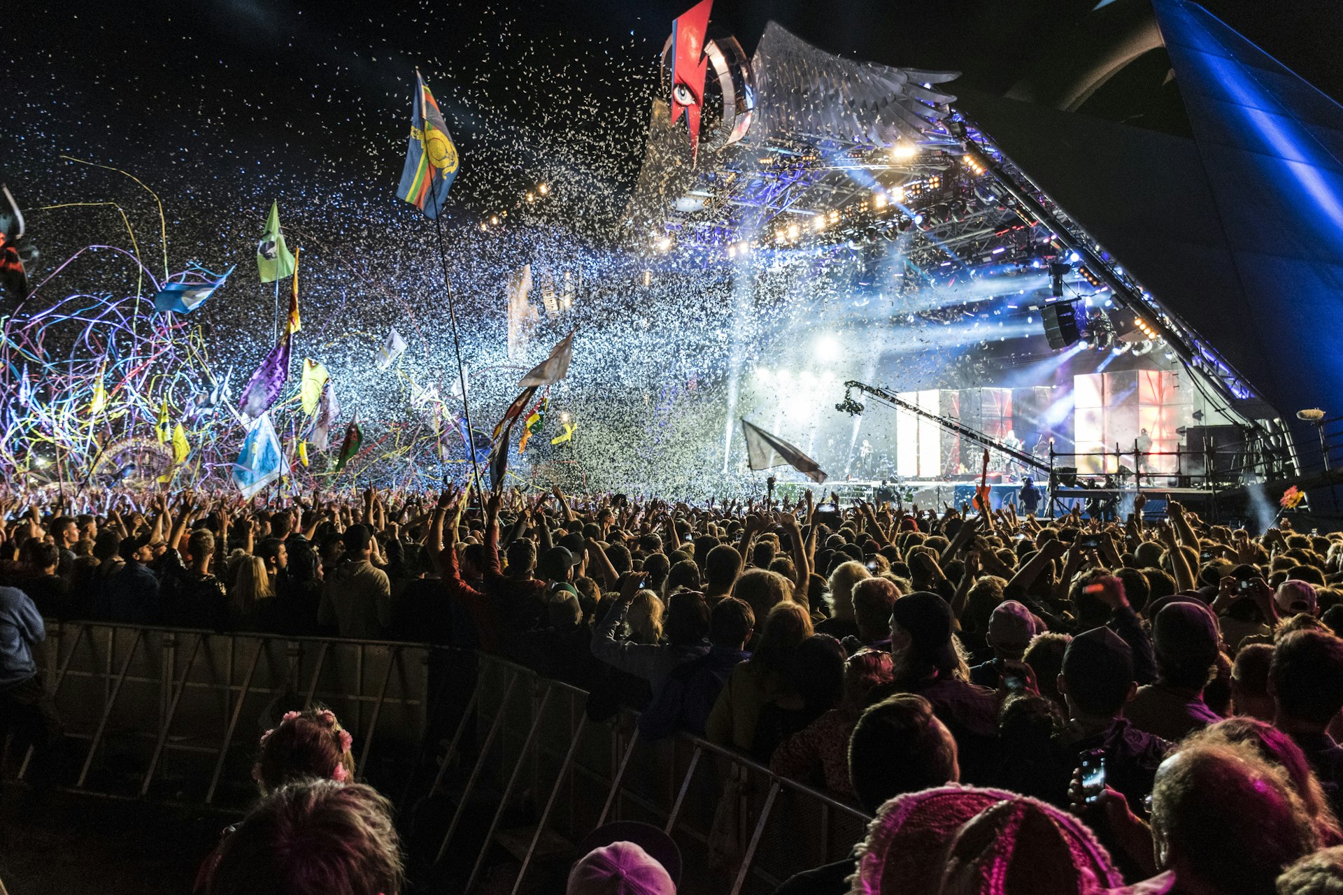 An explosion of confetti, tape and light from a pyramid shaped stage at Glastonbury Festival. 