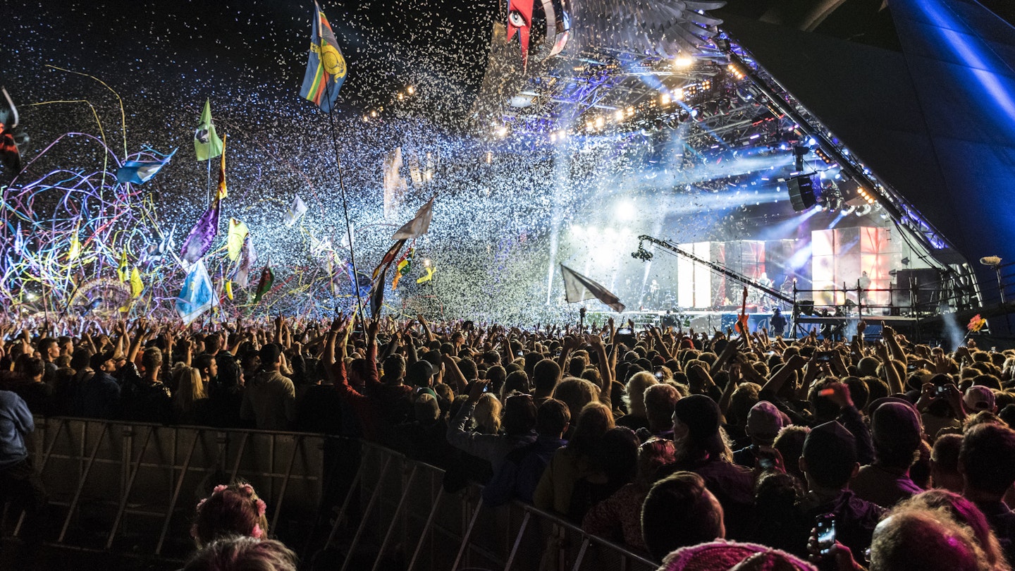 An explosion of confetti, tape and light from a pyramid shaped stage at Glastonbury Festival.