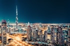 Fantastic nighttime skyline with illuminated skyscrapers. Elevated view of downtown Dubai, UAE. Colourful travel background.