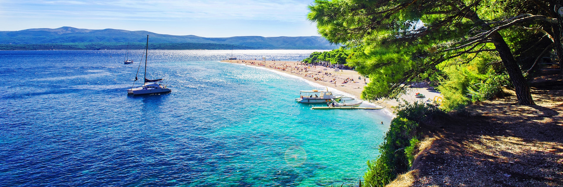 A few boats near the beach of Zlatni Rat (Golden Horn) on the island Brac.