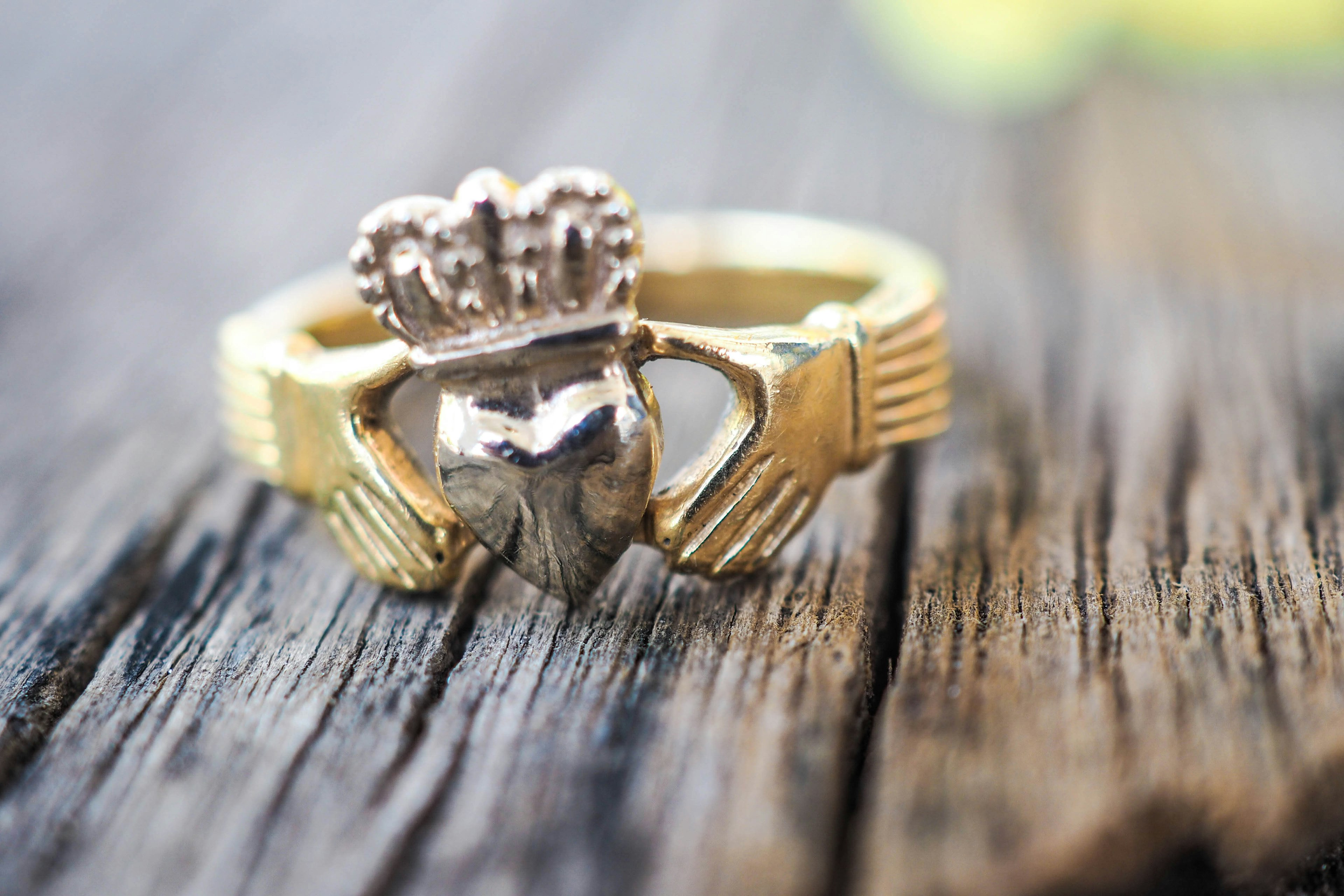 A close up of a Claddagh ring with a heart circled by two hands.