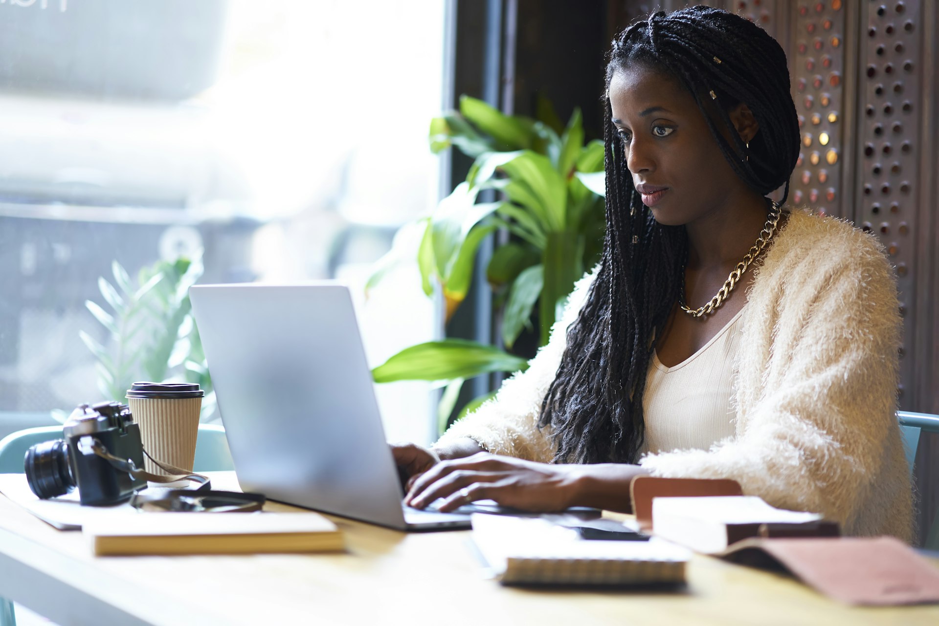 Black woman with a serious expression as she concentrates at her laptop