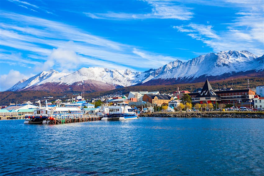 Boats ply the harbor of Ushuaia, Argentina, at Tierra del Fuego at South America’s southern tip Boats in the harbor of Ushuaia, Argentina, with snow-capped peaks in the distance