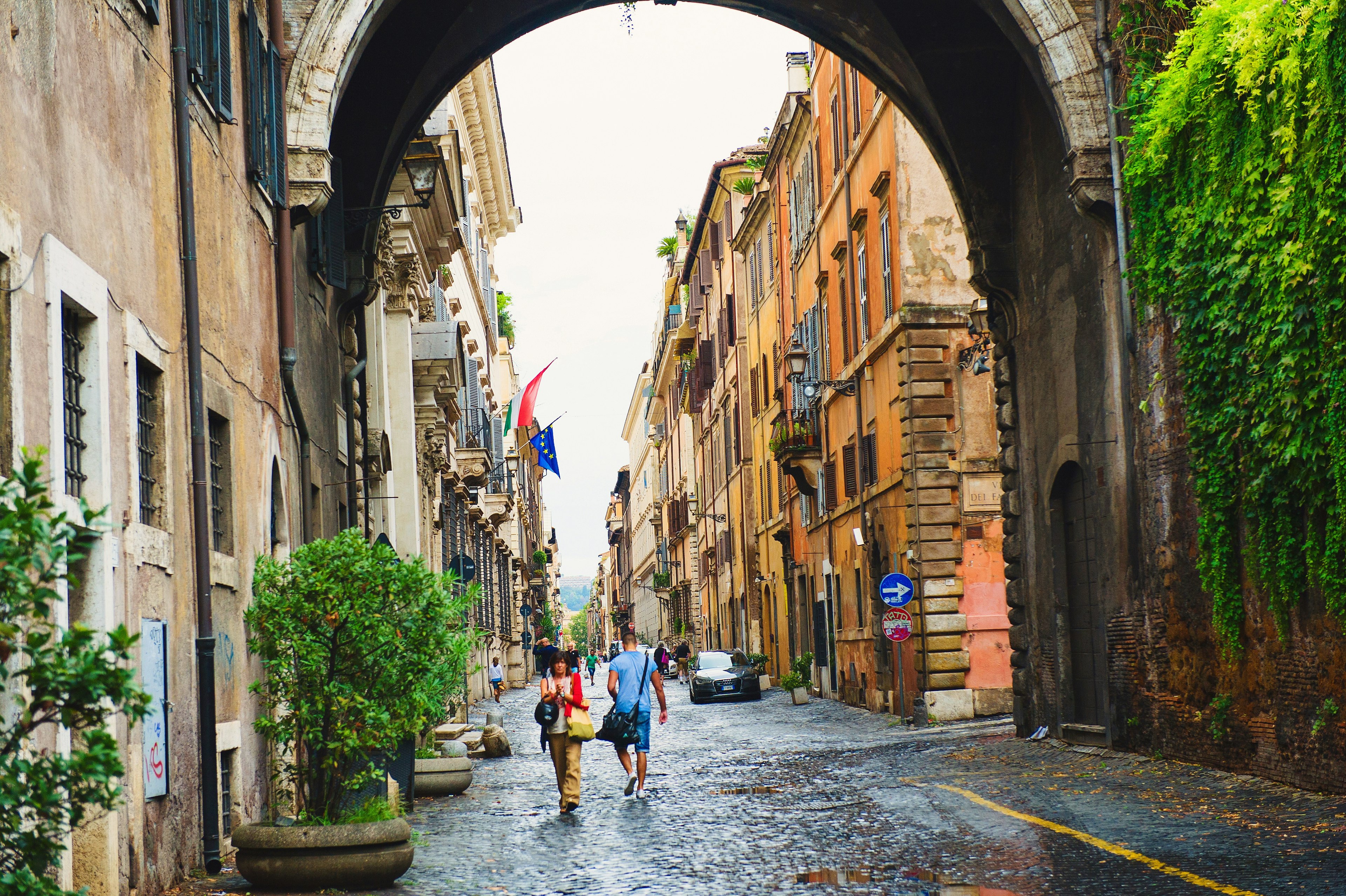 Tourists stroll along a cobbled street in Rome