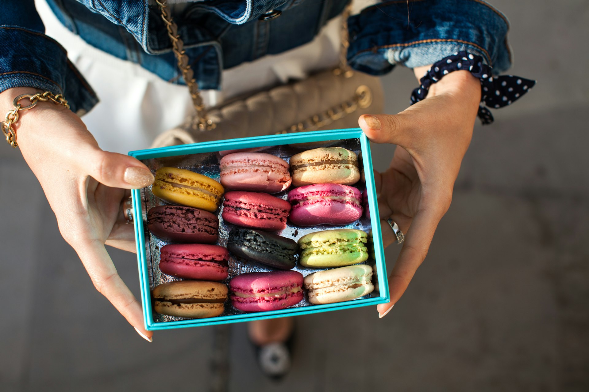 Woman holding box of colorful macarons