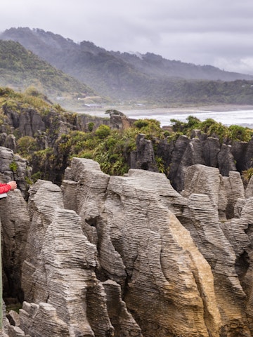 Two people look out over Punakaiki Pancake Rocks in Paparoa National Park, West Coast.