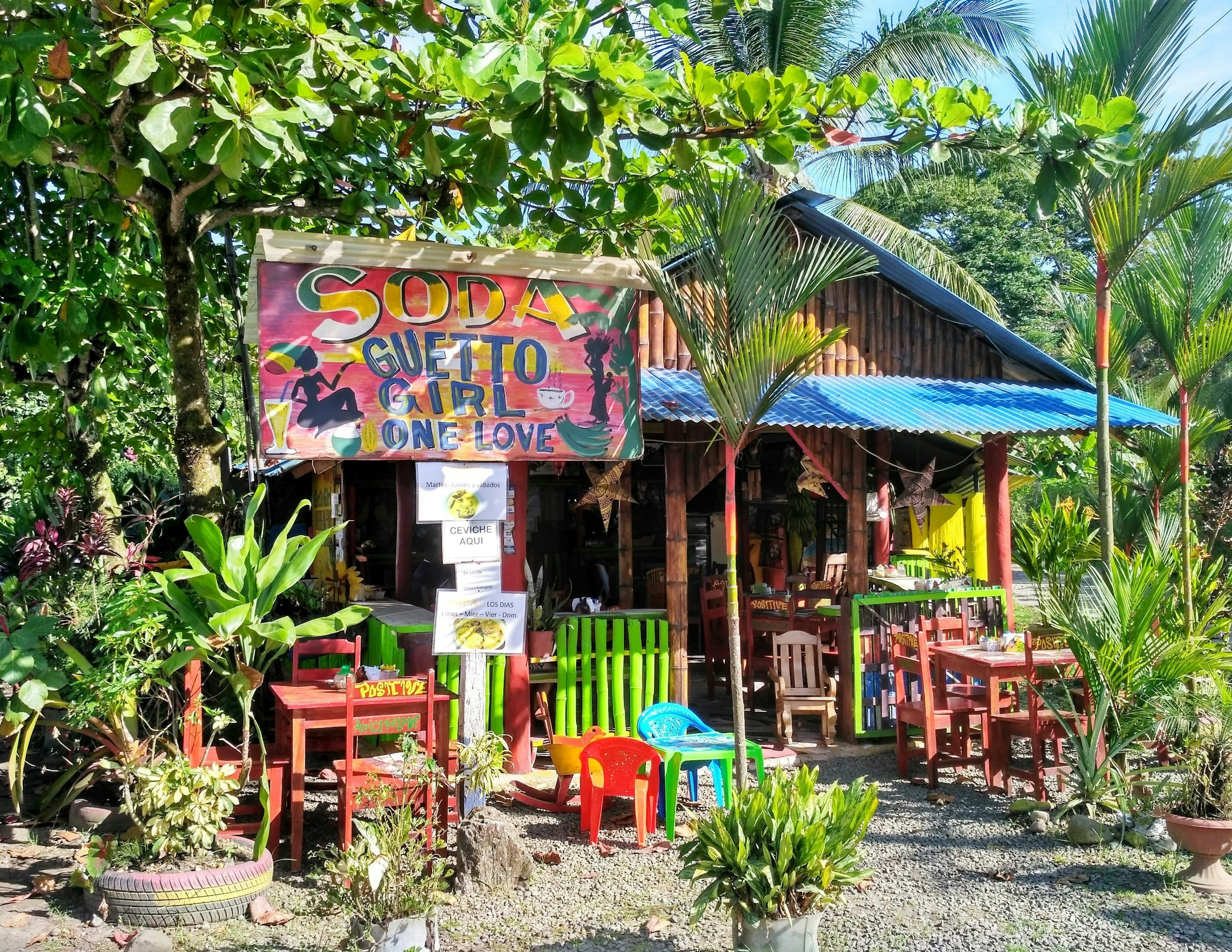 Traditional Costa Rican restaurant Soda – a colorful wooden house surrounded by lush tropical vegetation in Puerto Viejo