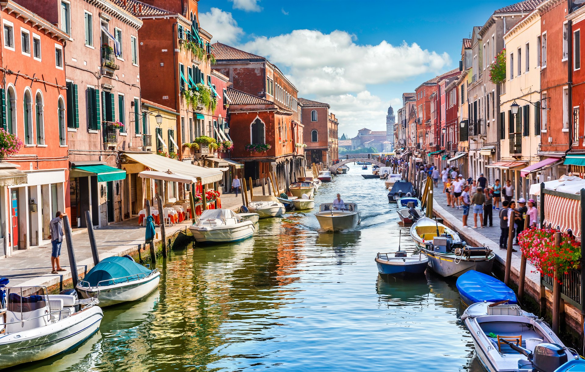 Visitors and boats in the canals of Italy's Murano island