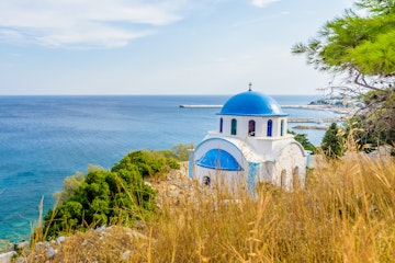 Blue and white Greek church of Agios Kirykos, situated on the rocky coast of Ikaria Island.
