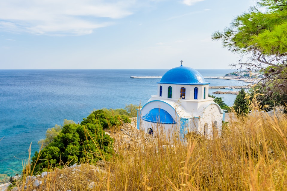 Blue and white Greek church of Agios Kirykos, situated on the rocky coast of Ikaria Island.