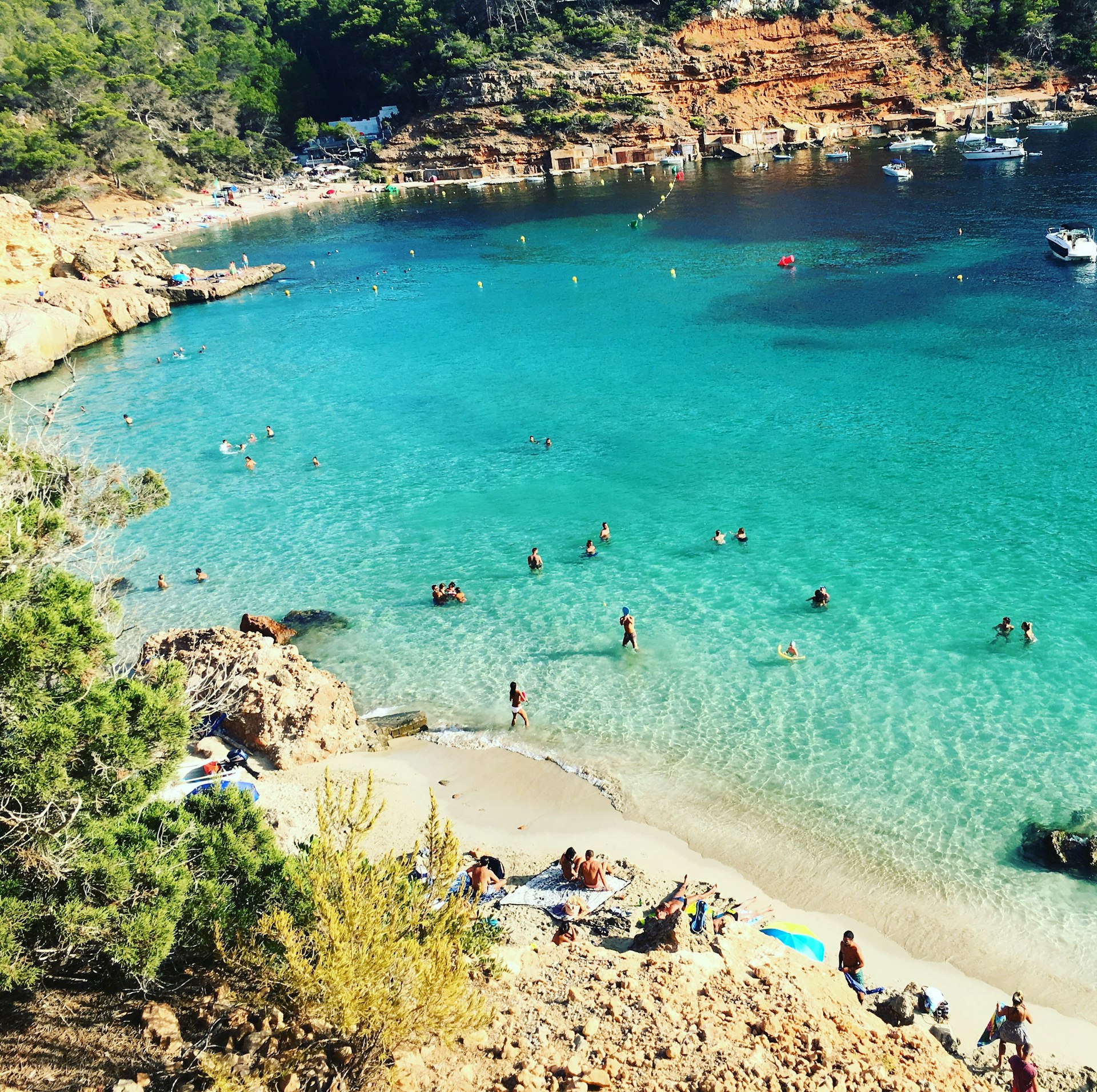 People swimming in the turquoise waters of Cala Salada