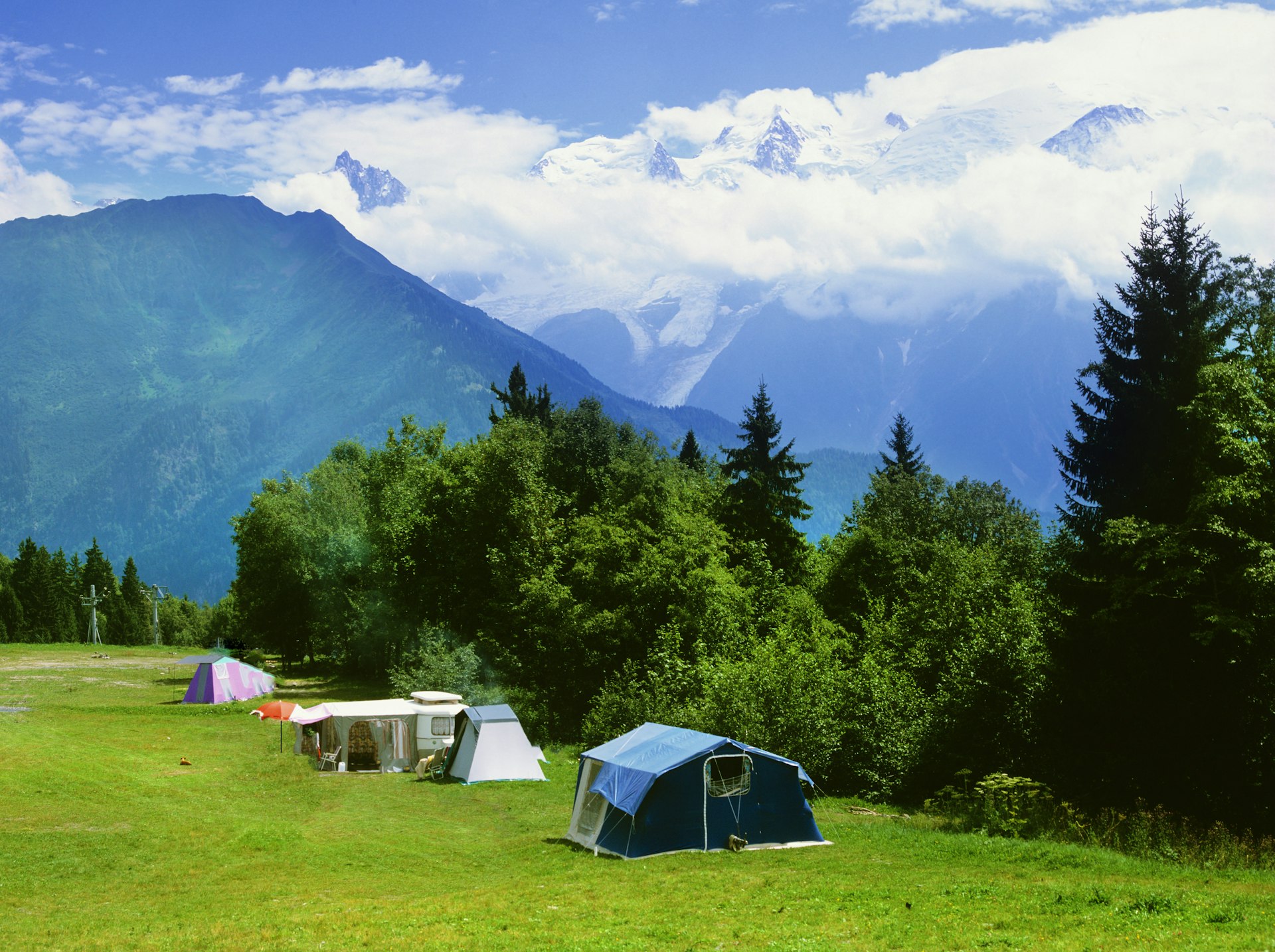 A remote campsite with three separate tent pitches in a mountain range 