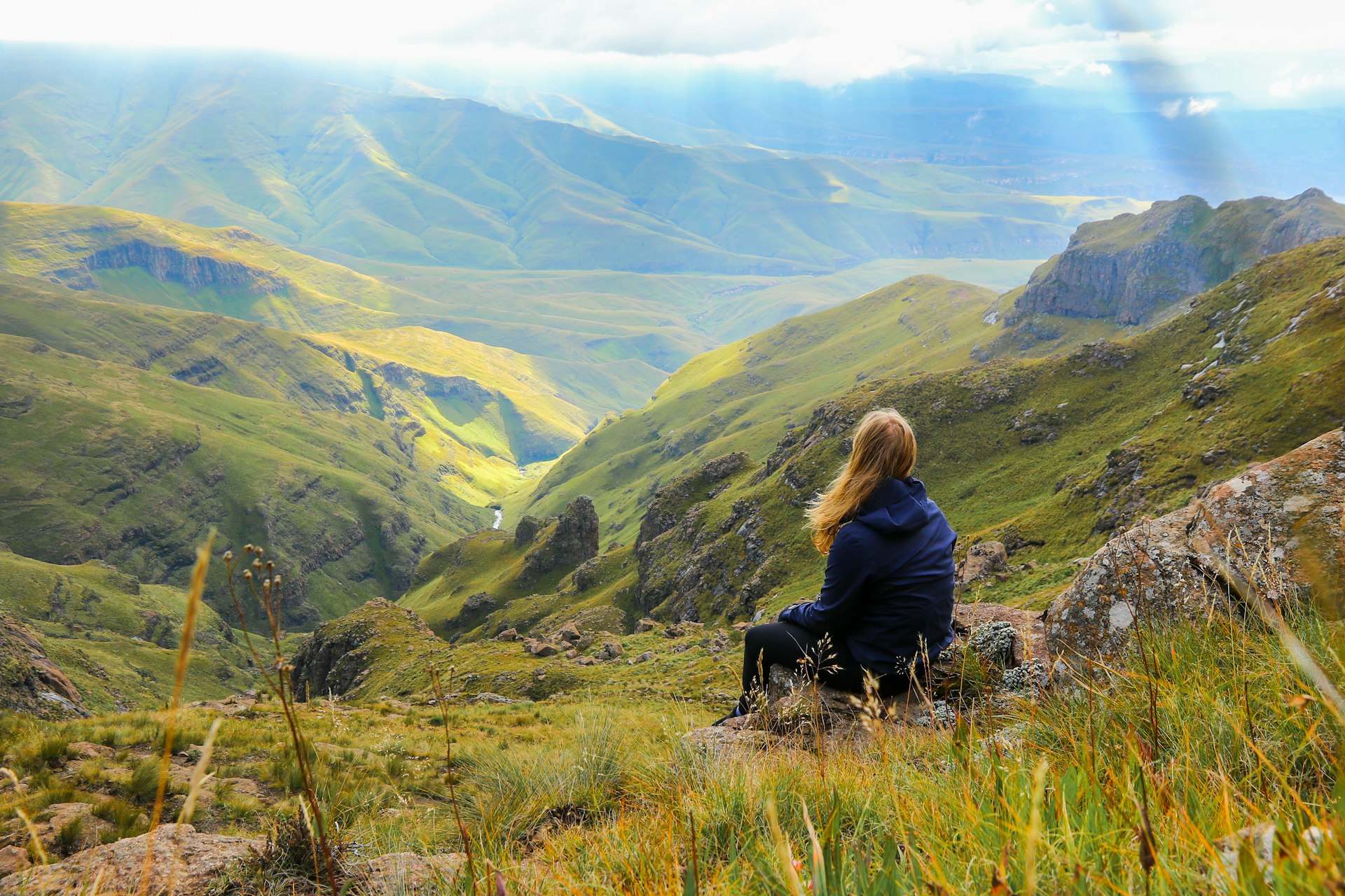 Woman contemplating the view from the top of the Sentinel Hike in the Drakensberg Mountains, Royal Natal National Park, Free State province of South Africa