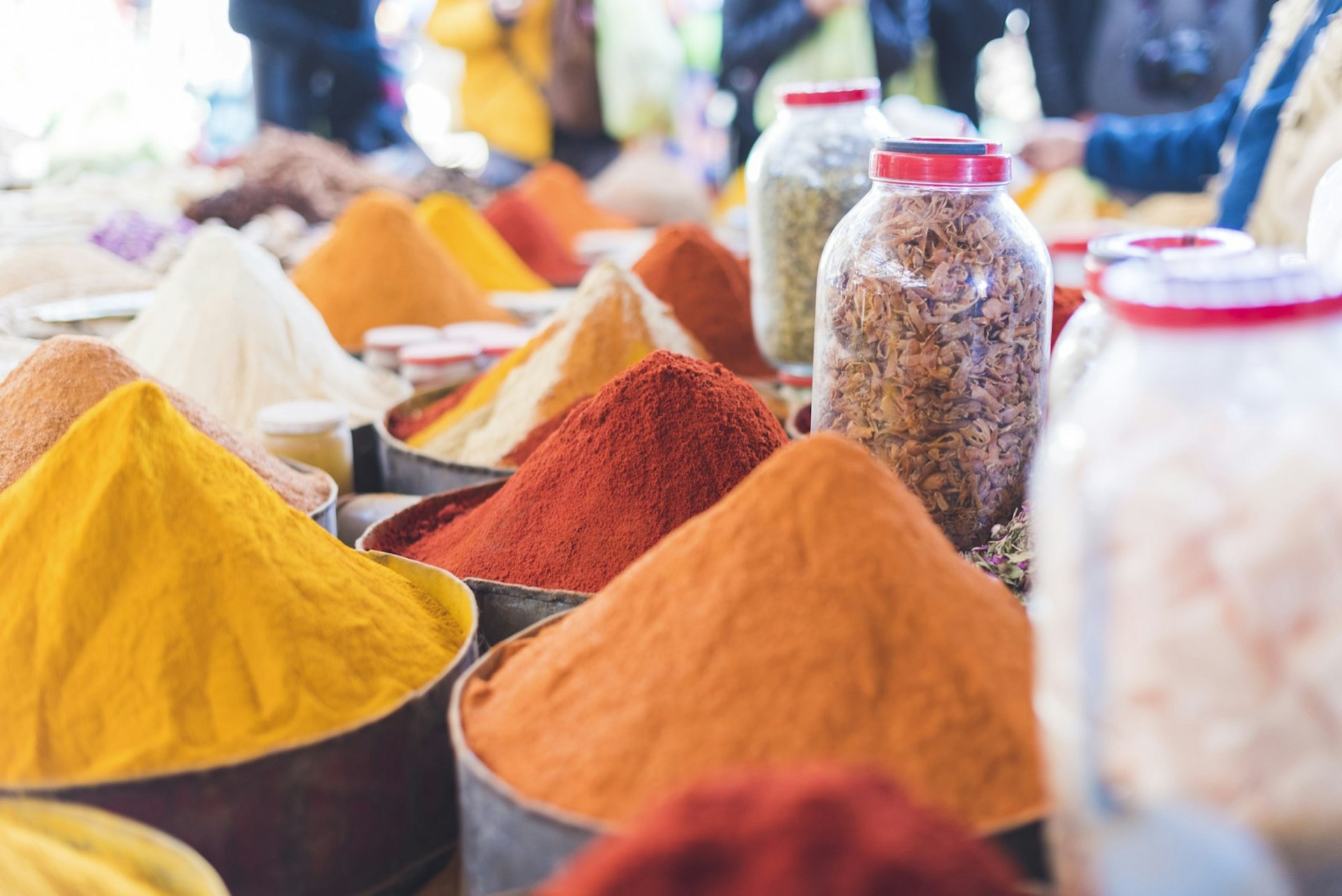 färgglada kryddor staplade i pyramider vid ett marknadsstånd i Marrakech