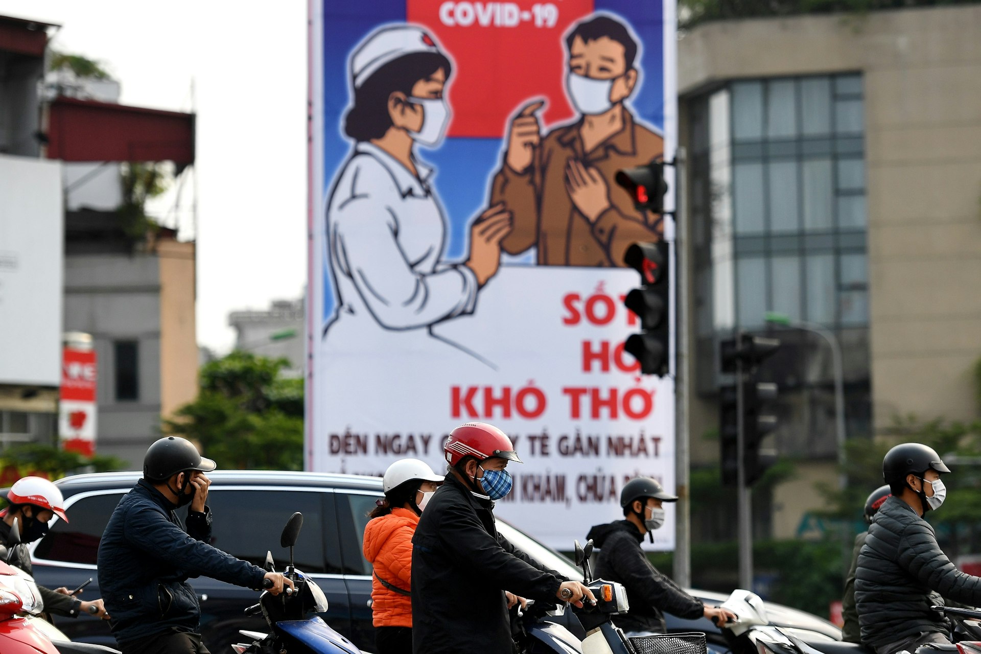 Motorists wearing face masks wait at a traffic light amid Vietnam's nationwide social isolation effort as a preventive measure against the spread of COVID-19 coronavirus in Hanoi on April 6, 2020.
