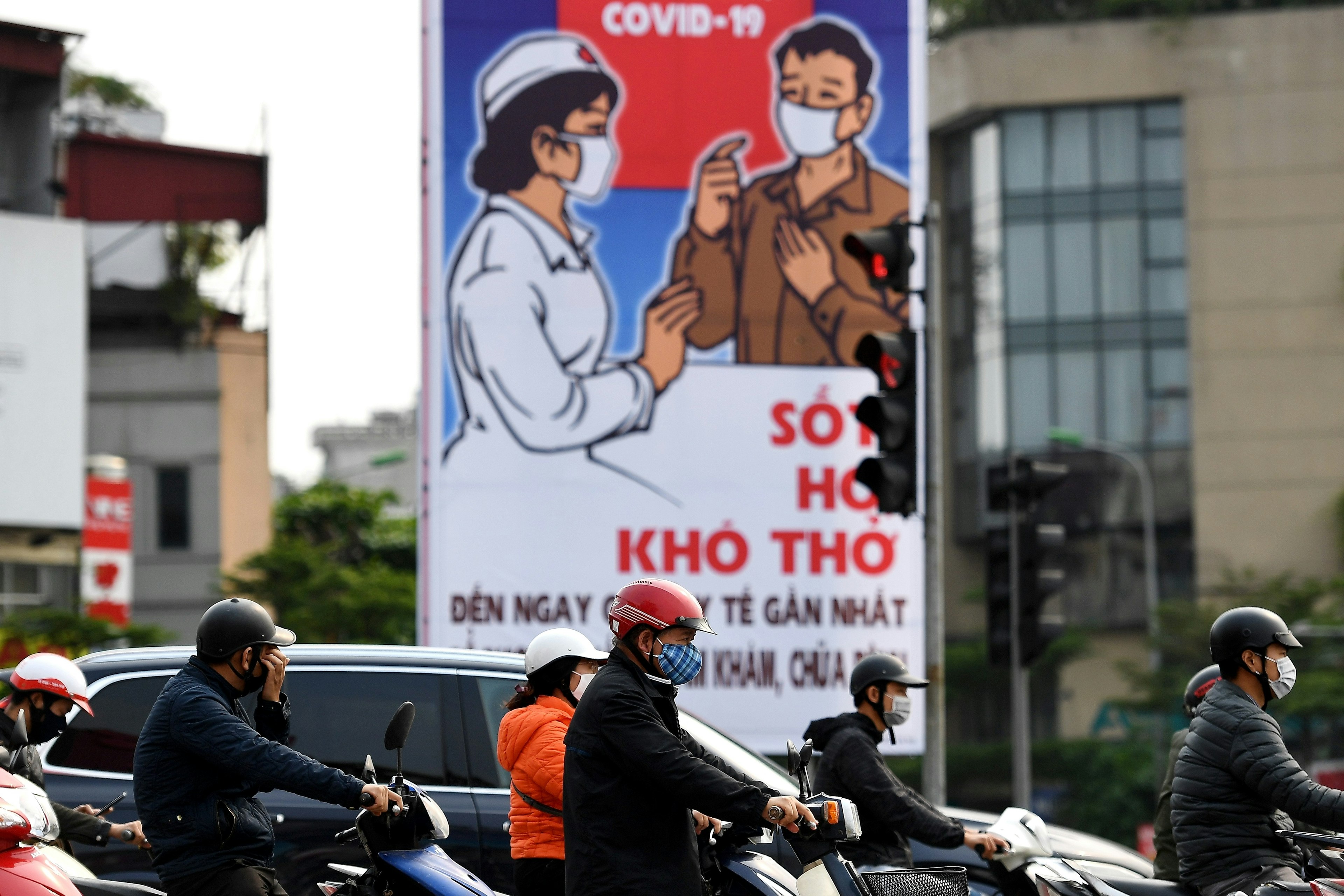 Motorists wearing face masks wait at a traffic light amid Vietnam's nationwide social isolation effort as a preventive measure against the spread of COVID-19 coronavirus in Hanoi on April 6, 2020. (Photo by Nhac NGUYEN / AFP) (Photo by NHAC NGUYEN/AFP via Getty Images)