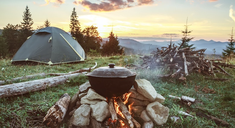 Tourist camp with fire, tent and firewood