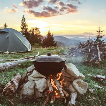 Tourist camp with fire, tent and firewood