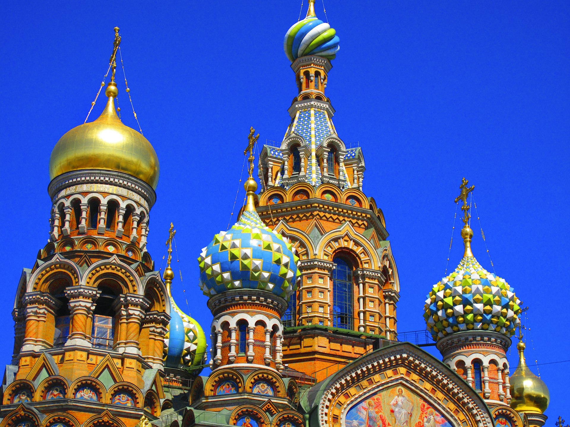 The domes of a colorful Russian Orthodox church against a blue sky