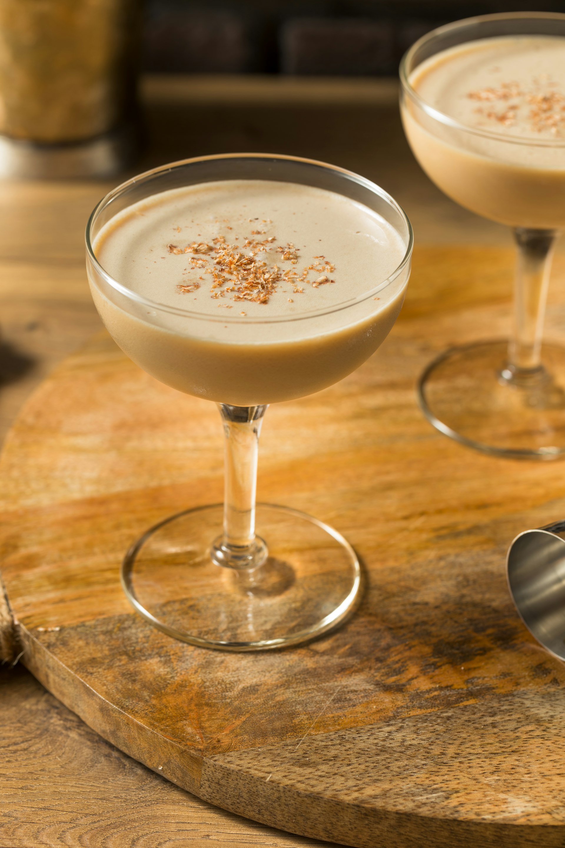 champagne glass filled with a brandy alexander and topped with nutmeg.