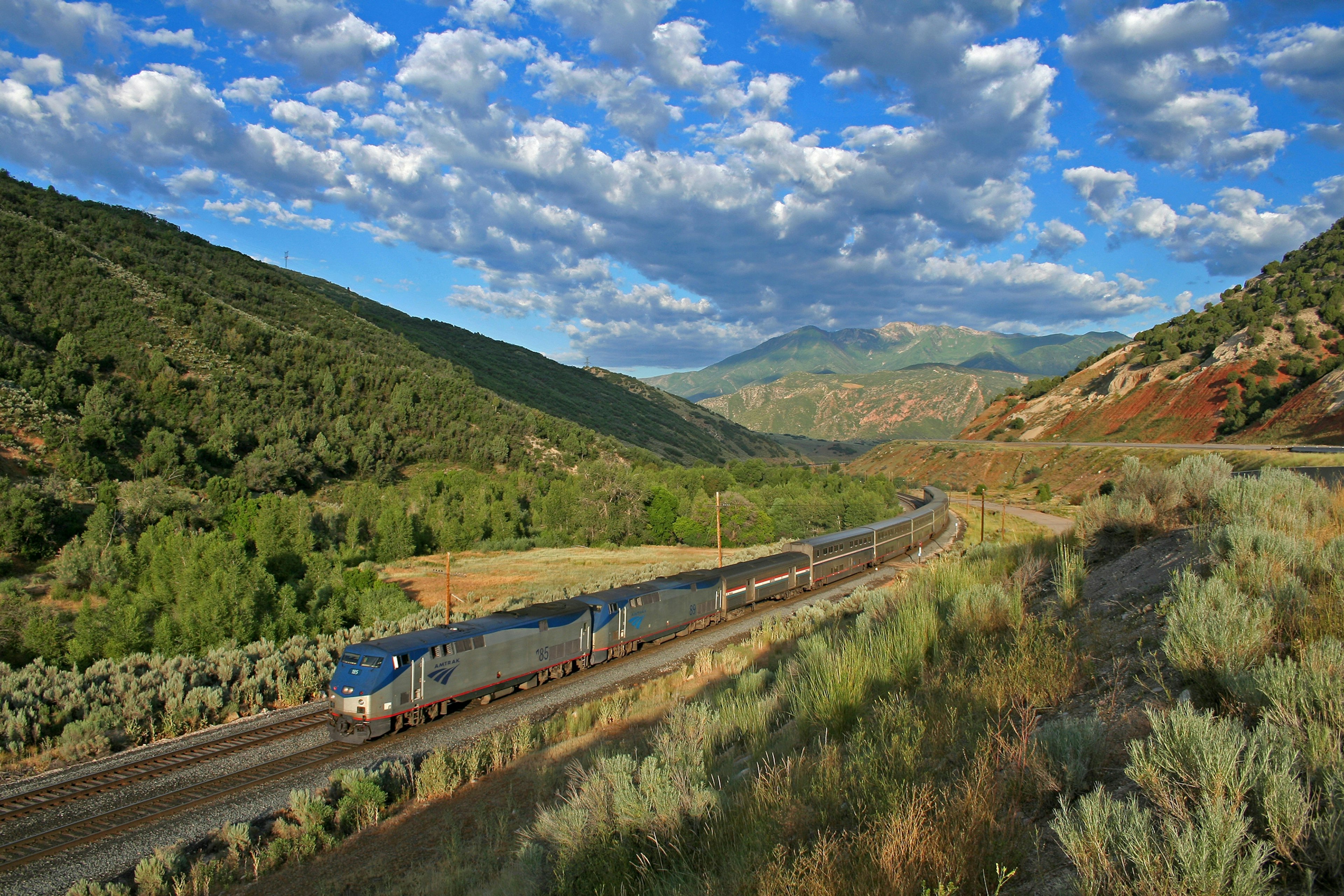 A train passing through a green landscape with blue skies