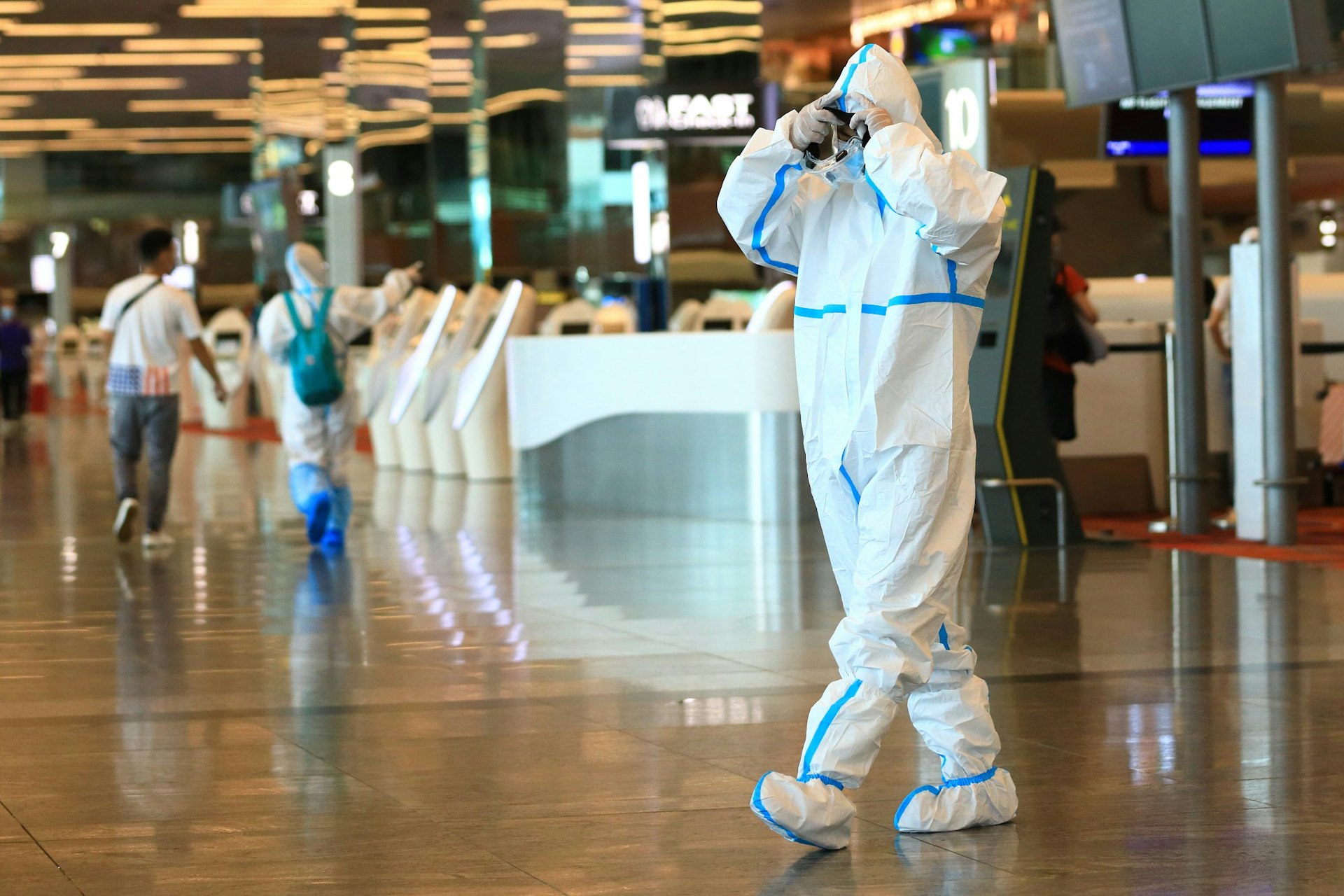 A traveler wearing PPE at Changi Airport