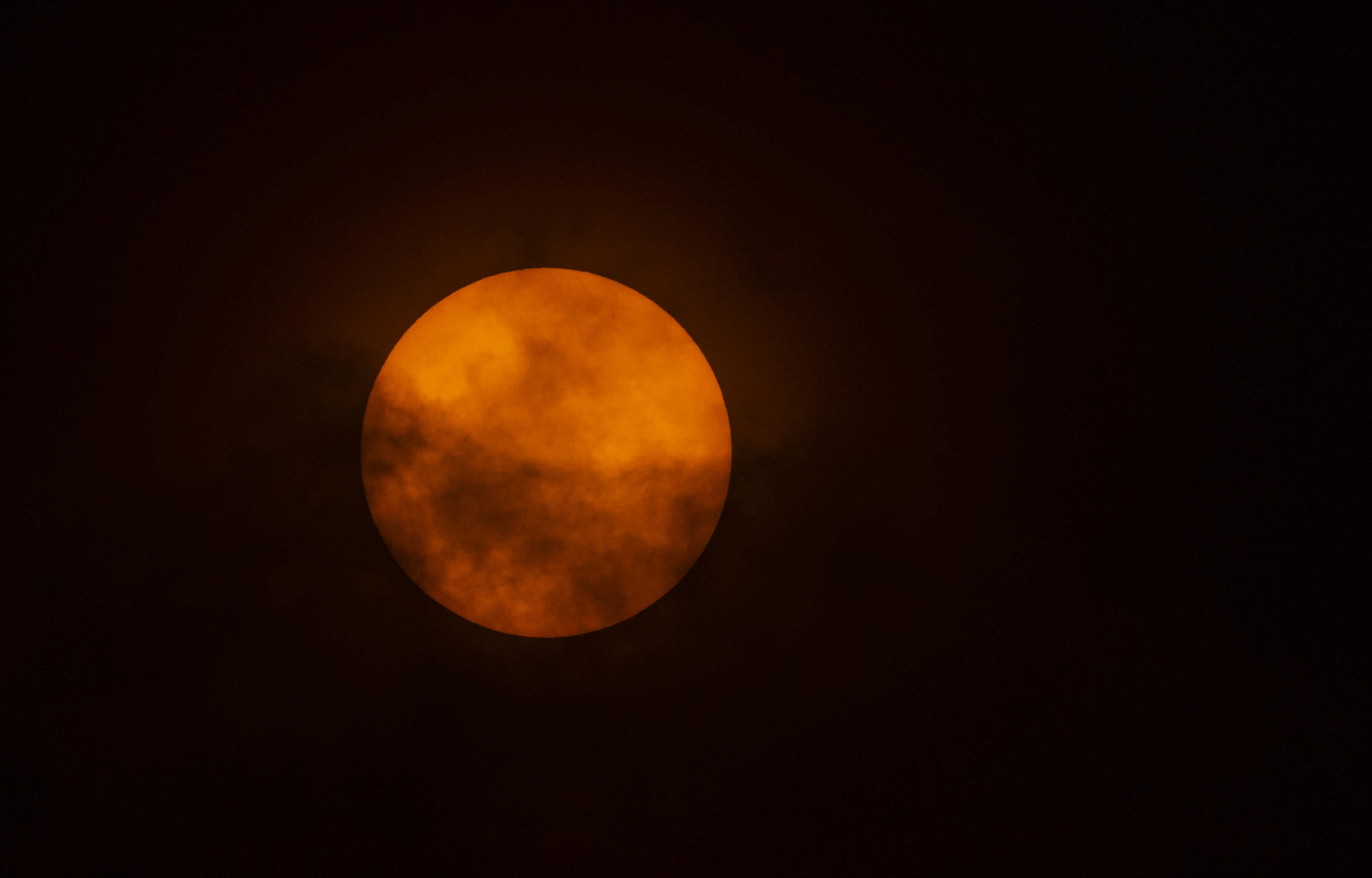 The sun is seen through the clouds on the slopes of Villarrica volcano