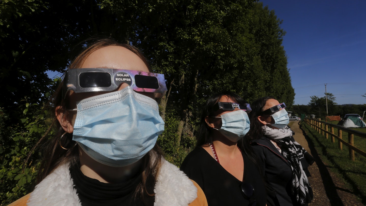 TEODORO SCHMIDT, CHILE - DECEMBER 13: People look at the sun before the total eclipse on December 13, 2020 in Teodoro Schmidt, Chile. The only total Solar Eclipse of the year will track across the southern end of South America on December 14. The unsual event attracts groups of tourists in the Chilean and Argentine Patagonia amid coronavirus restrictions to travel. (Photo by Marcelo Hernandez/Getty Images)