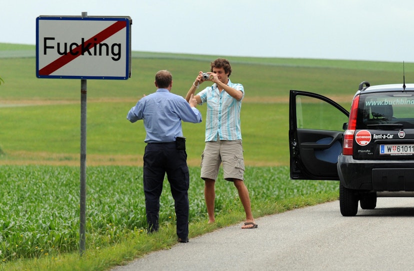Tourists take pictures of the road sign of the village of Fucking, some 35 km North of Salzburg,  on June 18, 2008. Due to its name, the village attracts many foreign tourists. The village is known to have existed as "Fucking" since at least 1070 and is named after a man from the 6th century called Focko. In 2004, mainly due to the stolen village traffic signs with its name on them, a vote was held on changing the village's name, but the residents voted against doing so.  AFP PHOTO / MLADEN ANTONOV (Photo credit should read MLADEN ANTONOV/AFP via Getty Images)