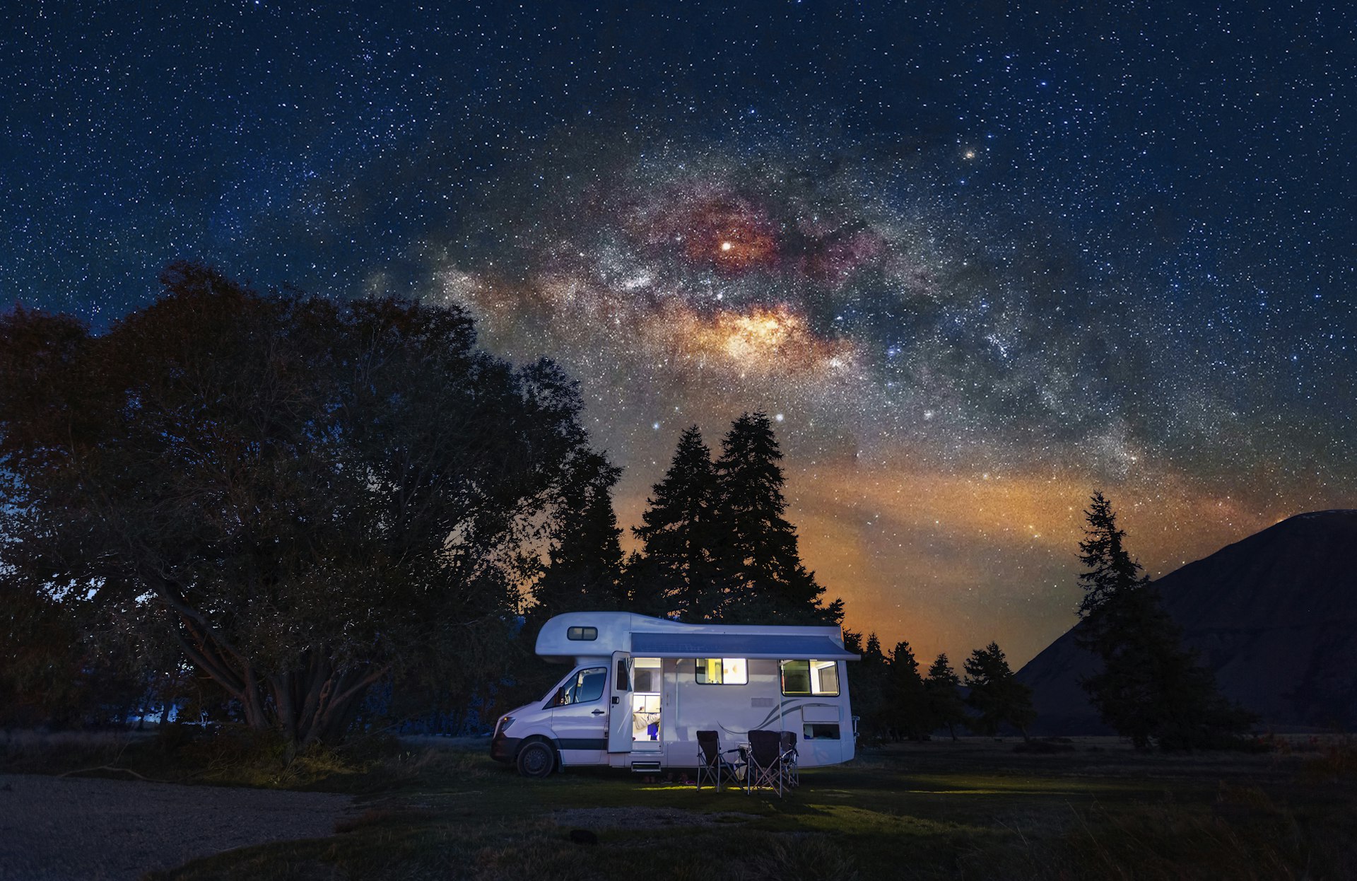 Motorhome at free camp site with milky way sky in New Zealand.