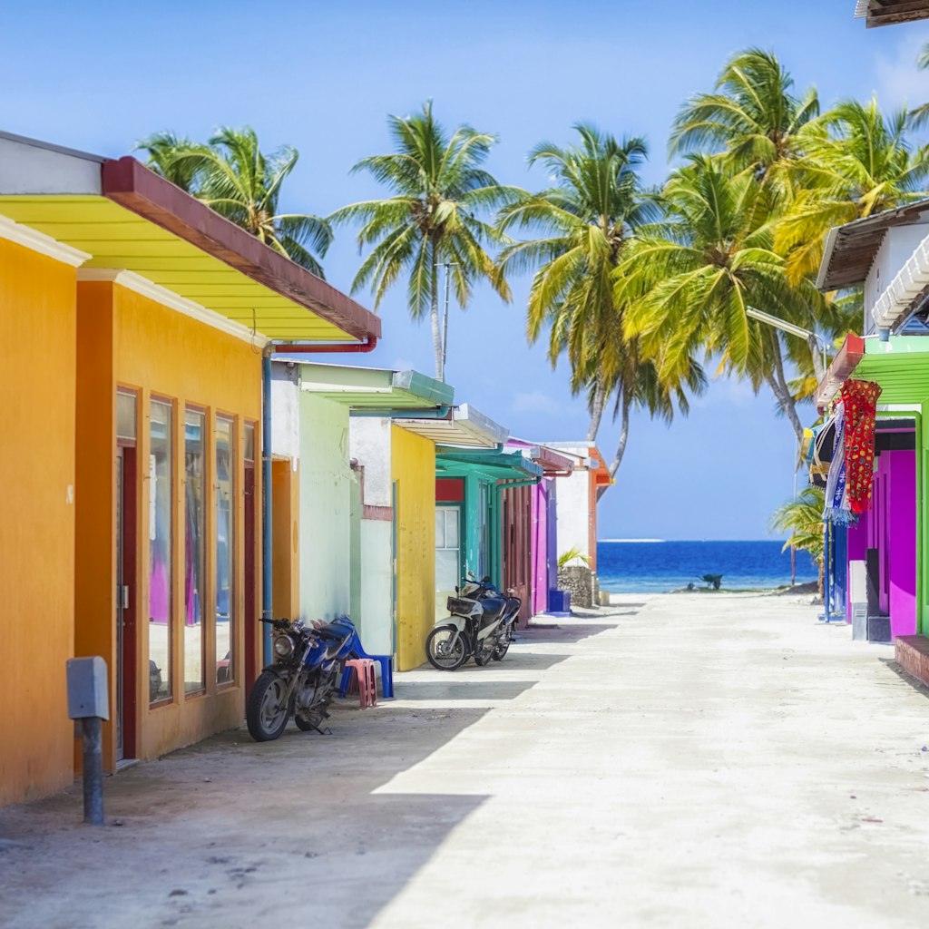 Shopping street with typically colourful house facades on Maafushi island in the Maldives.