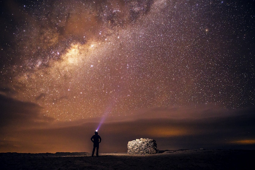 A traveler stands under the Milky Way galaxy as seen from the Atacama desert in northern Chile. The Atacama desert outside of San Pedro de Atacama is one of the world's best stargazing locations because of its combination of high altitude, dry air, and lack of light pollution.