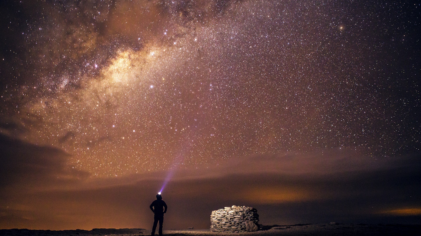 A traveler stands under the Milky Way galaxy as seen from the Atacama desert in northern Chile. The Atacama desert outside of San Pedro de Atacama is one of the world's best stargazing locations because of its combination of high altitude, dry air, and lack of light pollution.