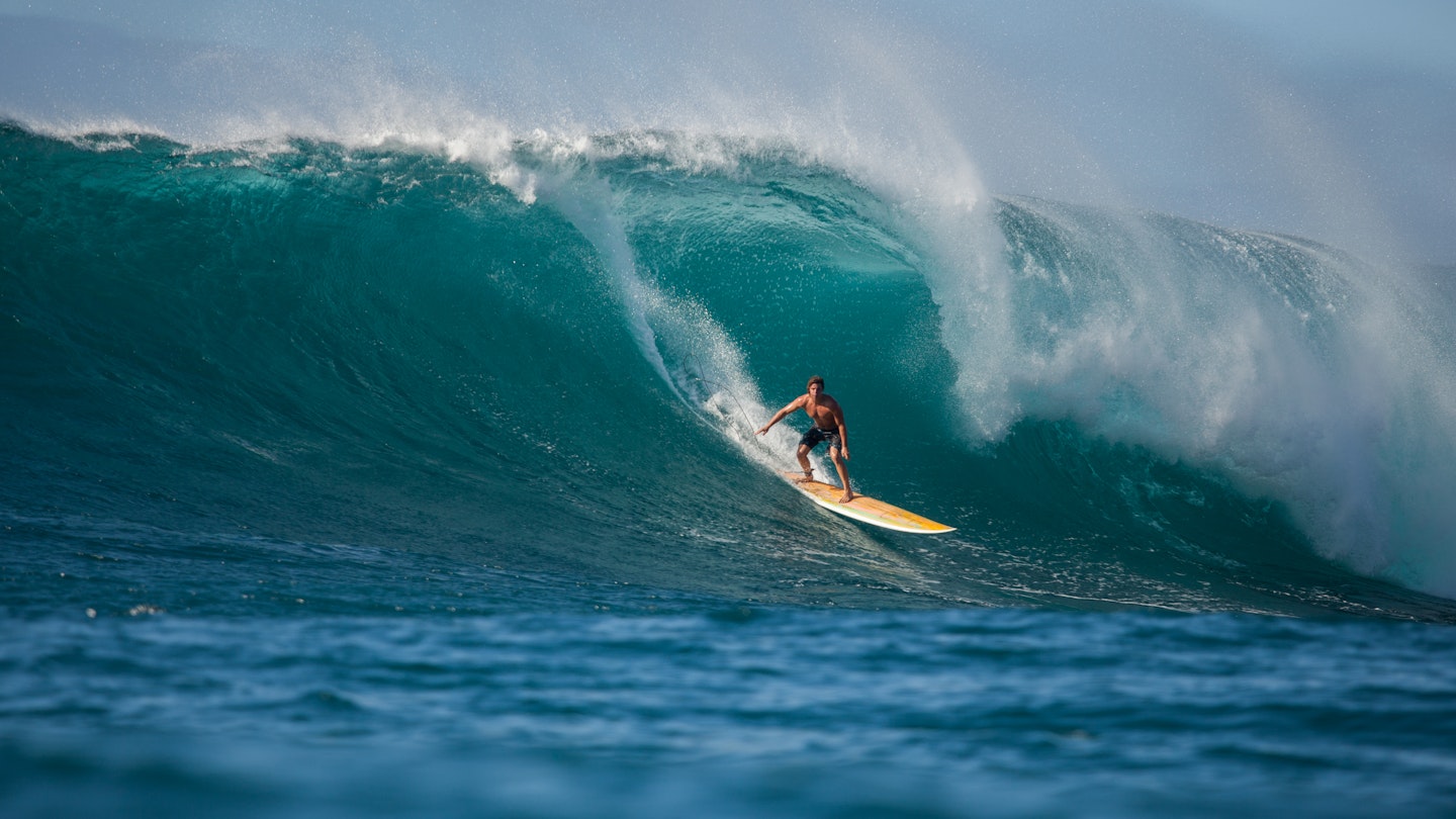 Man surfing a large barrelling wave at Waimea Bay.